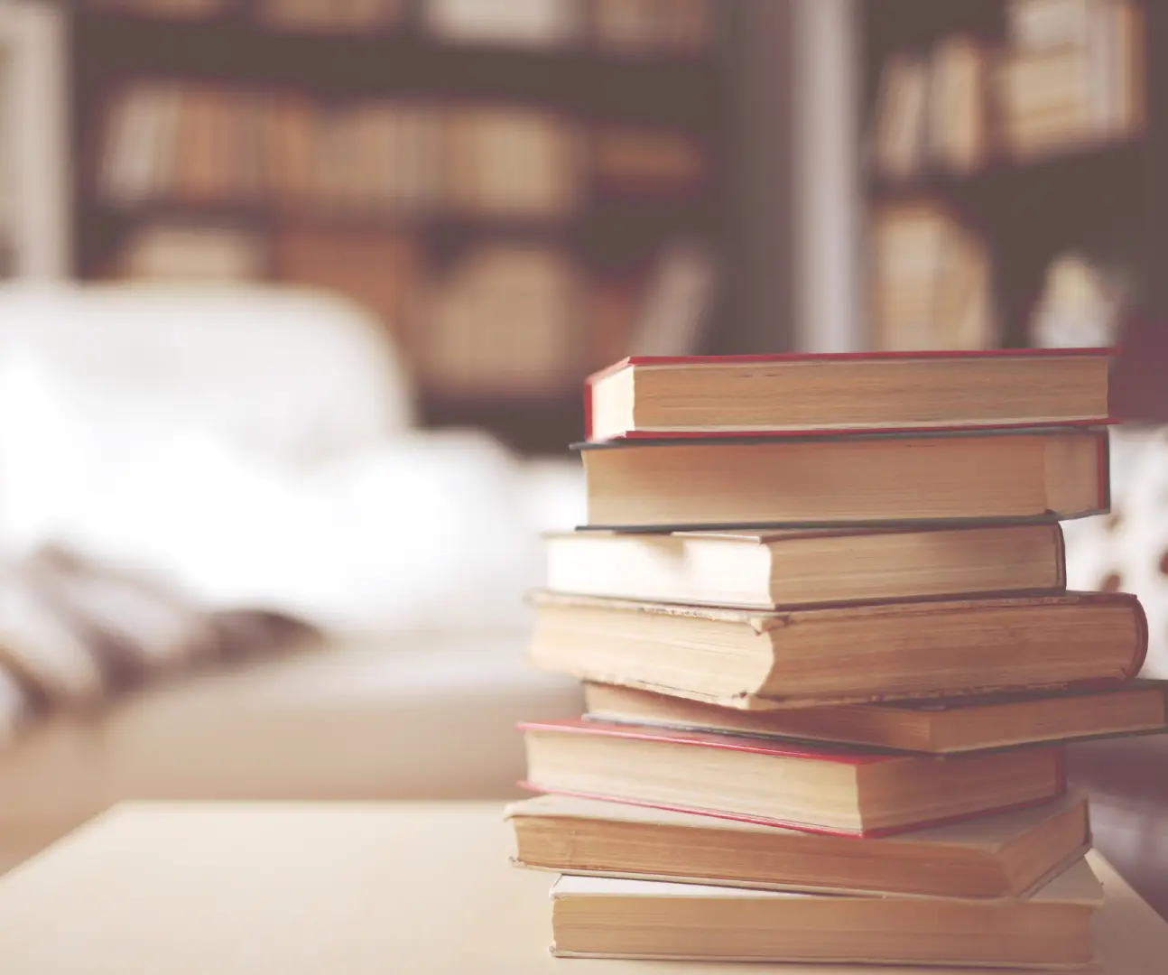 Stack of books on a wooden table.